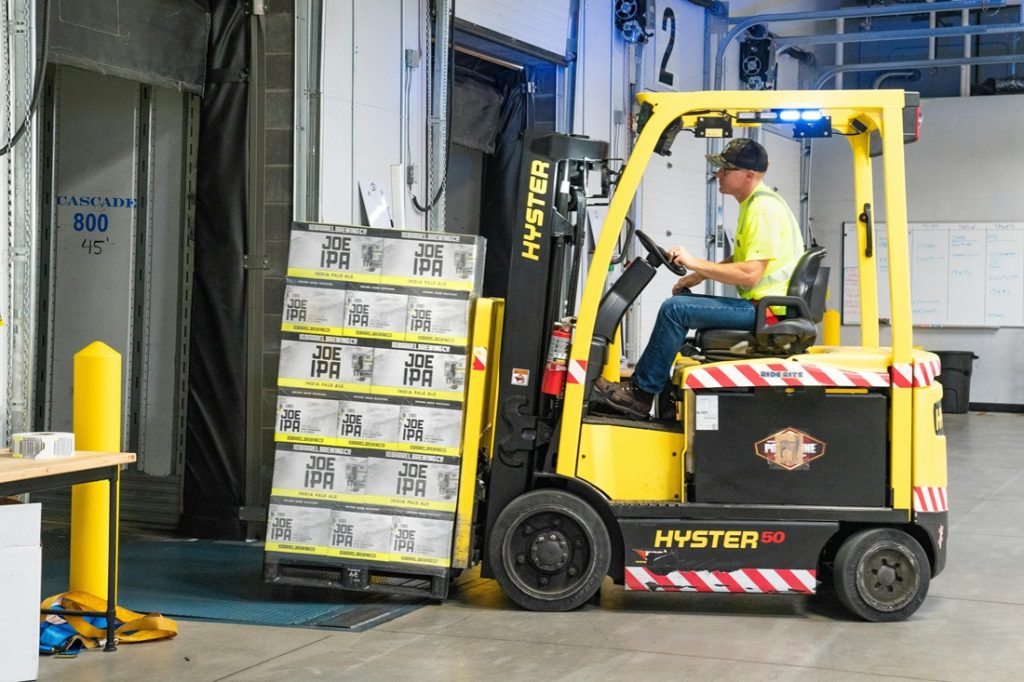 worker on forklift delivering stock in the warehouse